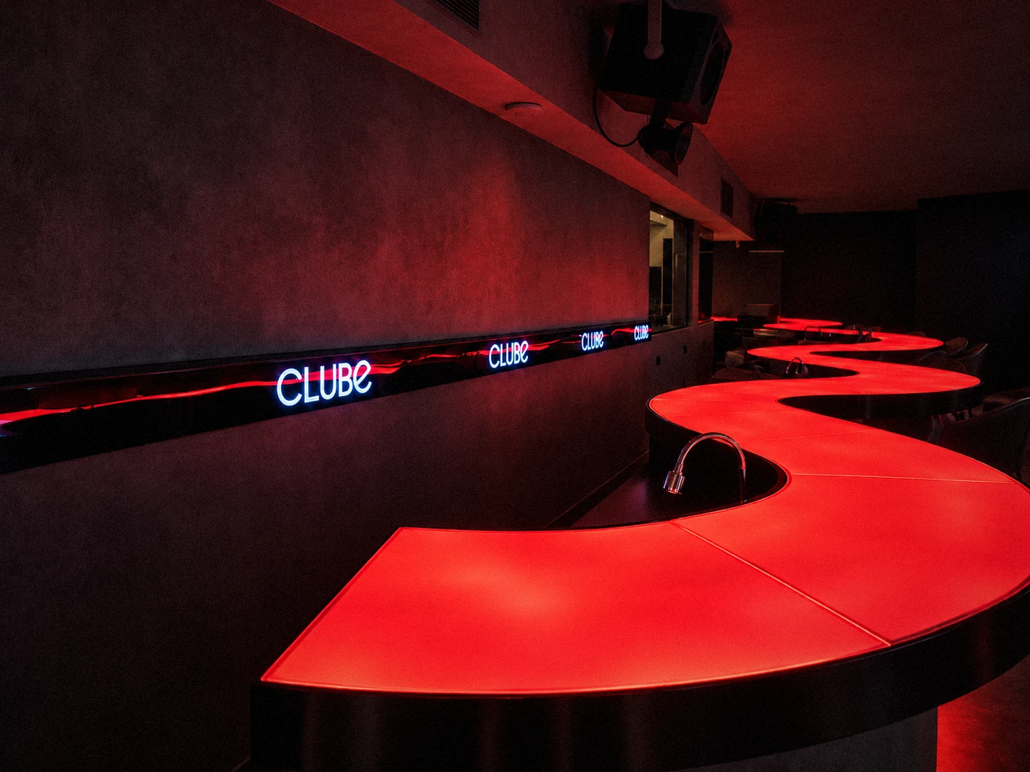 Balcão do bar na cor vermelha, com o logo no LED