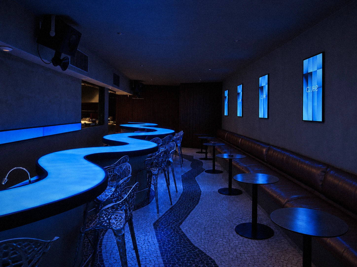 Bar do 1º andar com as telas na parede e o balcão de LED azul