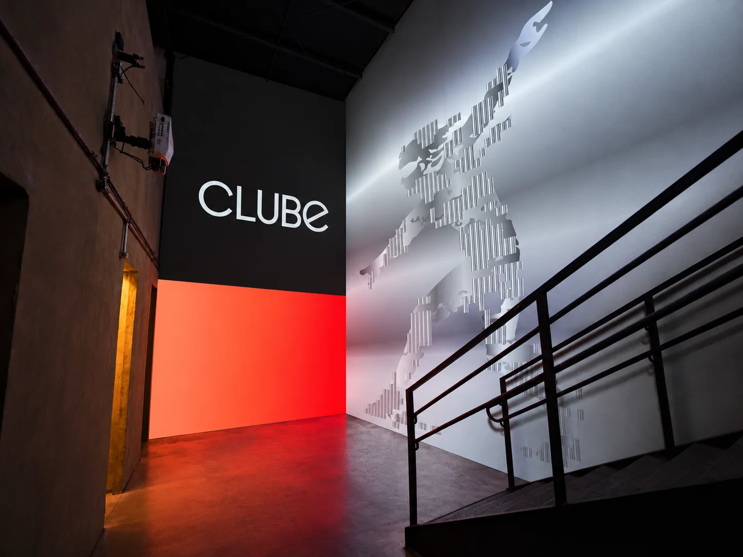 Sala imersiva com o logotipo e personagem em metal projetados